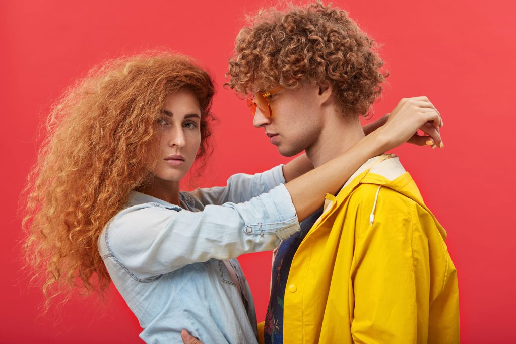 people, love, affection, dating, romance, relationships and happiness concept. romantic sweet beautiful european couple with ginger curly hair wearing stylish clothes hugging or dancing indoors